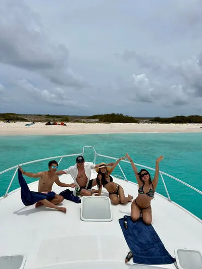 Invitados relajándose en la proa junto a una playa de arena blanca en Curazao