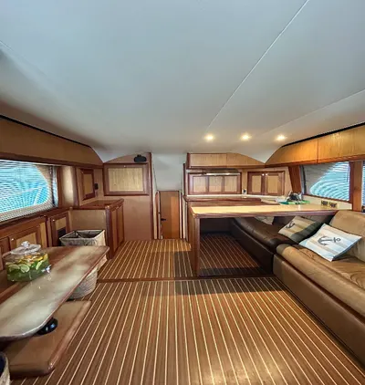 Salón con acabados de madera y cocina en el interior del yate privado
