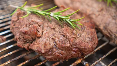 Filete a la parrilla con romero cocinándose en la barbacoa
